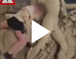 A damaged lion statue outside the Brussels Stock Exchange, with people gathered around