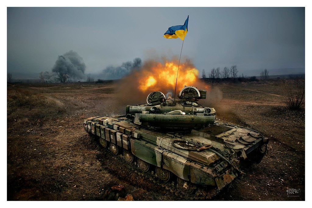 In this powerful image, a Ukrainian tank stands as a formidable symbol of strength and resilience. The armored vehicle, adorned with the national colors, exudes a sense of readiness and determination. Its sleek, well-defined silhouette against the backdrop showcases the technological prowess of Ukrainian military engineering. Dust kicked up around the tank suggests a dynamic setting, possibly a military exercise or deployment. The tank stands as a testament to the dedication and preparedness of the Ukrainian armed forces, ready to safeguard the nation's security with unwavering resolve.