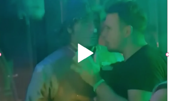 In a neon-lit club, a person engages in a hilarious, drunken conversation with a statue, set to the backdrop of the iconic Grease song "You're the One That I Want.