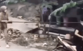 A man dismounting his scooter after noticing a woman with a purse.