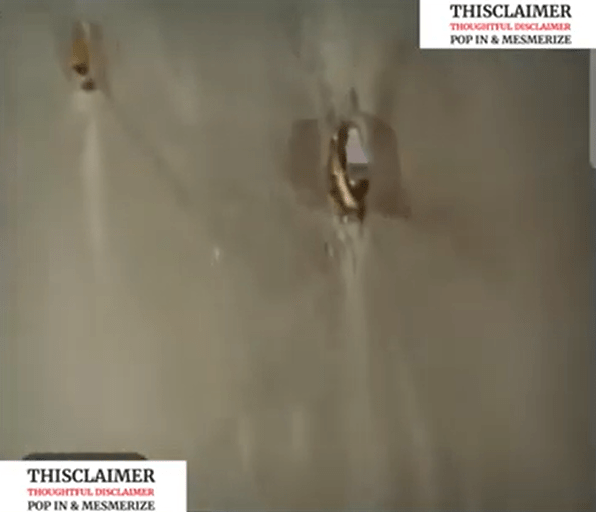 A man finds a small hole in a wall and prepares to peek through, unaware of the imminent danger.