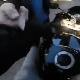 A man pointing a knife at the biker while making threats.