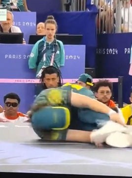 Rachael Gunn on the ground in a worm-like breakdancing move.