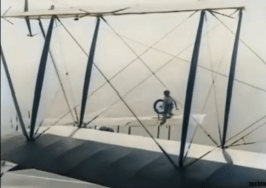 Gladys mid-air, jumping from the wing of one plane to the wing of another, as part of the repair operation.