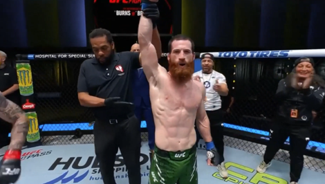 A photo of UFC fighter Yanal Ashmouz raising his hands in celebration after winning his fight.