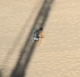 Crane tower casting a shadow over a sunbathing woman on a beach, with the operator shouting in Spanish.