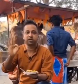 POV shot of a man reviewing street food with the vendor in the background scratching his behind.