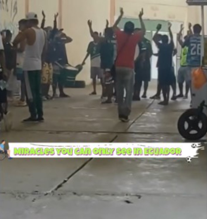 A man stands and dances energetically in the crowd at a soccer stadium, appearing to have no disability.