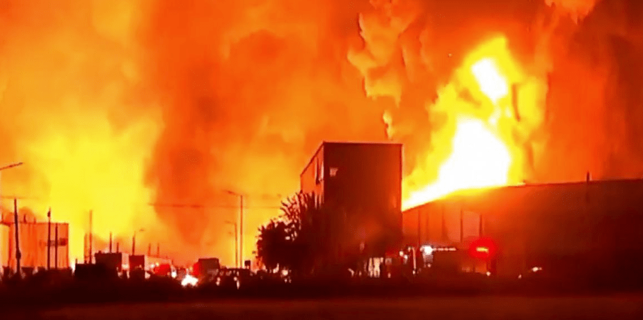 Large plume of black smoke rising from a burning industrial complex while firefighters spray water on the flames in Buenos Aires’ Ezeiza area after a chemical plant explosion.