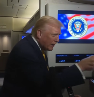 Donald Trump pointing toward a Bloomberg reporter while interrupting her during a press gaggle.