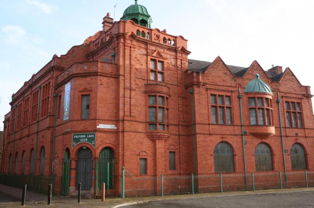 Front exterior of Salford Lads and Girls Club in Salford, showing the historic brick building and entrance steps