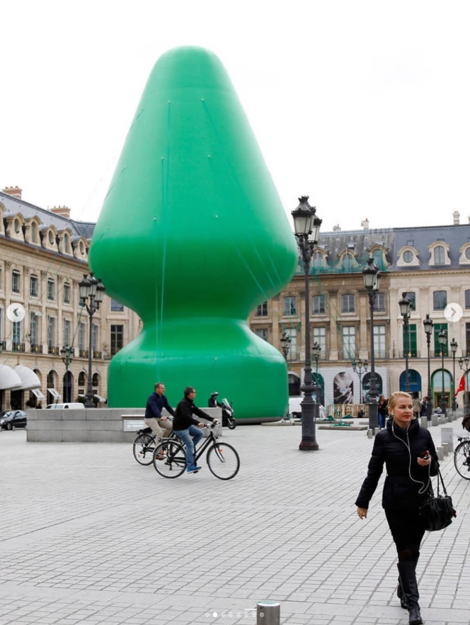 The giant green inflatable Tree sculpture by Paul McCarthy fully inflated in Place Vendôme, Paris, with historic buildings in the background.