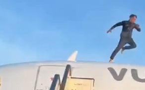 A man standing on top of a commercial airplane at Valencia Airport during a security incident
