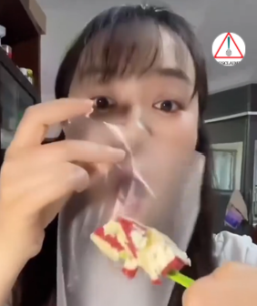 Woman with plastic wrap over her mouth trying to eat cake, illustrating a risky viral weight-loss trend