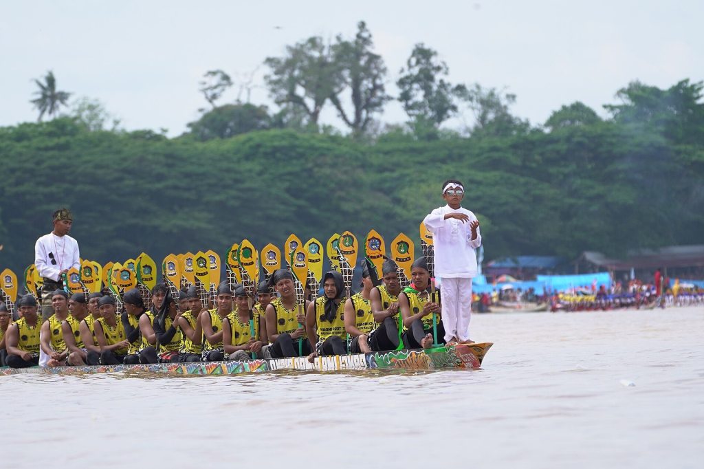 A traditional Pacu Jalur longboat team racing along the Kuantan River in Indonesia.