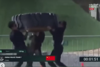 Three Chinese female SWAT officers work together to carry a heavy tyre during a tactical fitness challenge.