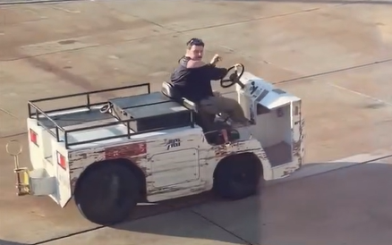 A man drives an airport tug across the tarmac at John Wayne Airport in California during a reported security breach.